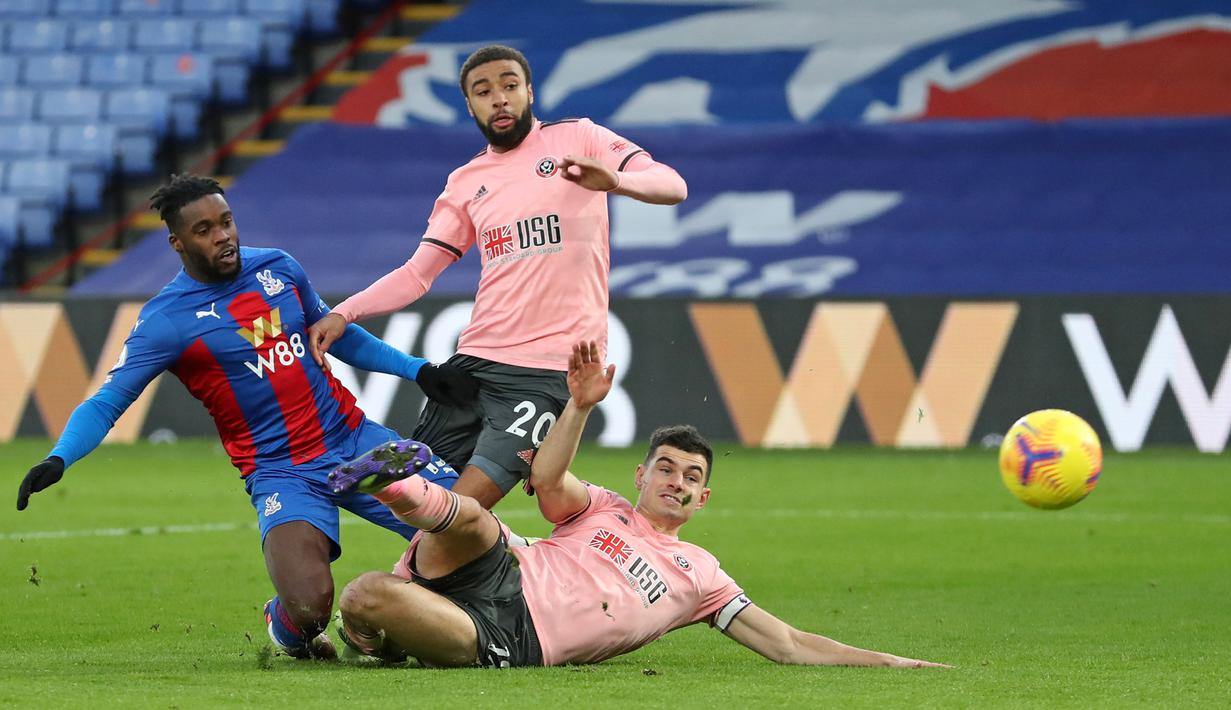 Gelandang Crystal Palace, Jeffrey Schlupp (kiri) melepaskan tendangan yang berbuah gol pertama timnya ke gawang Sheffield United dalam laga lanjutan Liga Inggris 2020/21 pekan ke-17 di Selhurst Park, Sabtu (2/1/2021). Crystal Palace menang 2-0 atas Sheffield United. (AFP/Catherine Ivill/Pool)