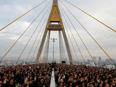 Ribuan warga hadir mengenakan baju hitam-hitam saat acara HUT terakhir almarhum Raja Thailand, Bhumibol Adulyadej di atas Jembatan Bhumibol, Bangkok, Thailand, Senin (5/12). Raja Bhumibol meninggal di usia 88 tahun. (REUTERS/Jorge Silva)