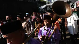 Seniman Betawi saat menampilkan pertunjukan Tanjidor dalam Lebaran Tenabang 2022 di kawasan Tanah Abang, Jakarta, Sabtu (4/6/2022). Kegiatan yang menampilkan berbagai kesenian Betawi, makanan tradisional, perlombaan, dan bazar UMKM itu mengangkat tema KolaborAksi. (Liputan6.com/Angga Yuniar)