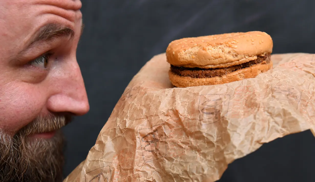 Casey Dean memeriksa burger McDonald's yang dibeli pada 1995 dan disimpan di gudang Australia selama bertahun-tahun, di Melbourne, 7 November 2019. Pada November 2020, burger itu akan berusia 25 tahun, rencananya Dean dan Nits akan membawanya ke restoran tempat mereka membelinya. (William WEST/AFP)