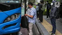 Para pekerja yang mengenakan masker bersiap menaiki bus di Jakarta, Rabu (2/2/2022). Sebanyak 5.110 pasien COVID-19 di Indonesia sembuh, membuat total pasien sembuh mencapai 4.148.804 orang. (Liputan6.com/Faizal Fanani)
