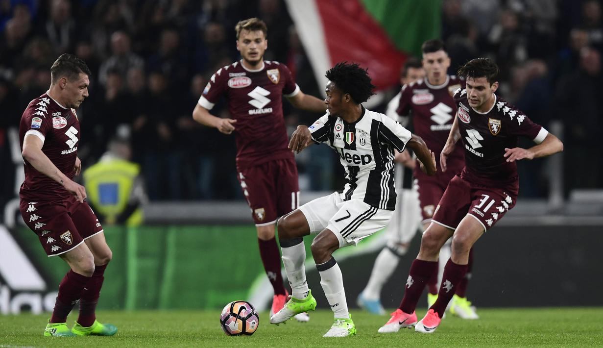 Gelandang, Juventus, Juan Cuadrado, berusaha melewati beberapa pemain Torino. Dalam pertandingan tersebut kedua tim memakai formasi 4-2-3-1. (AFP/Miguel Medina)