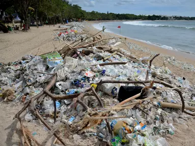 Sampah termasuk sampah plastik terlihat saat pembersihan pantai Kuta dekat Denpasar di pulau wisata Bali, Indonesia (6/1/2021). Tahun 2021 baru berjalan, tapi masalah sampah kembali terjadi di Indonesia, terutama di Pantai Kuta di Badung, Bali. (AFP/Sonny Tumbelaka)