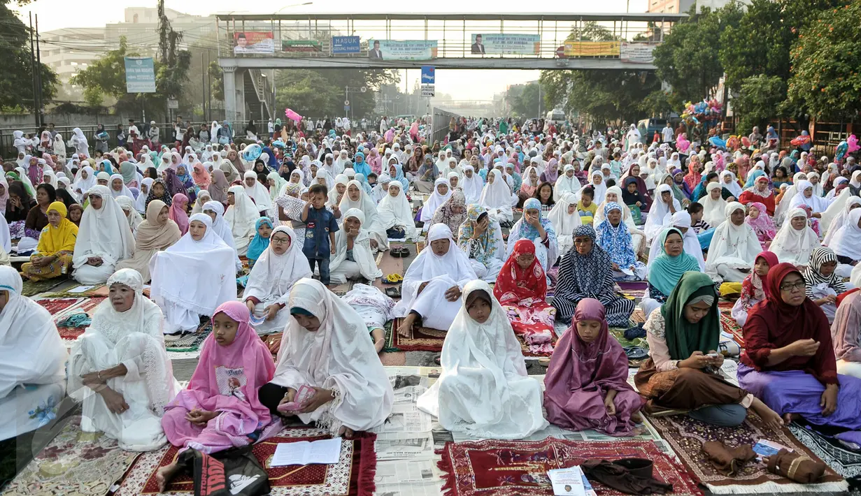 Umat muslim mendengarkan khutbah saat pelaksanaan salat Idul Fitri di kawasan Jatinegara, Jakarta, Rabu (6/7). Ruas Jalan Jatinegara Barat disulap menjadi tempat pelaksanaan salat. (Liputan6.com/Yoppy Renato)