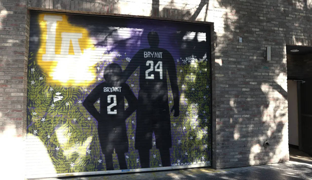 Lukisan mural bintang LA Lakers, Kobe Bryant bersama putrinya, Gianna terpampang di jalanan Los Angeles, California, Selasa (26/1/2021). Lukisan dibuat untuk mengenang 1 tahun tragedi kecelakaan helikopter yang menewaskan keduanya. (Getty Images via AFP/Rich Fury)