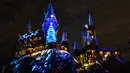Cahaya warna-warni menghiasi kastil Dunia Harry Potter dihiasi cahaya biru di Universal Studios Hollywood, Universal City (16/11). Pertunjukan ini bertemakan 'The Magic of Christmas at Hogwarts Castle'. (AFP Photo/Chris Delmas)