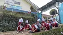 Beberapa pelajar Sekolah Dasar (SD) Negeri 04 Kampung Sempur Lebak, Desa Petir, Kecamatan Dramaga, Kabupaten Bogor, Jawa Barat memam\kai sepatu mereka sebelum masuk halaman sekolah setelah sebelumnya menyeberangi Sungai Cihideung. (Liputan6.com/Herman Zakharia)