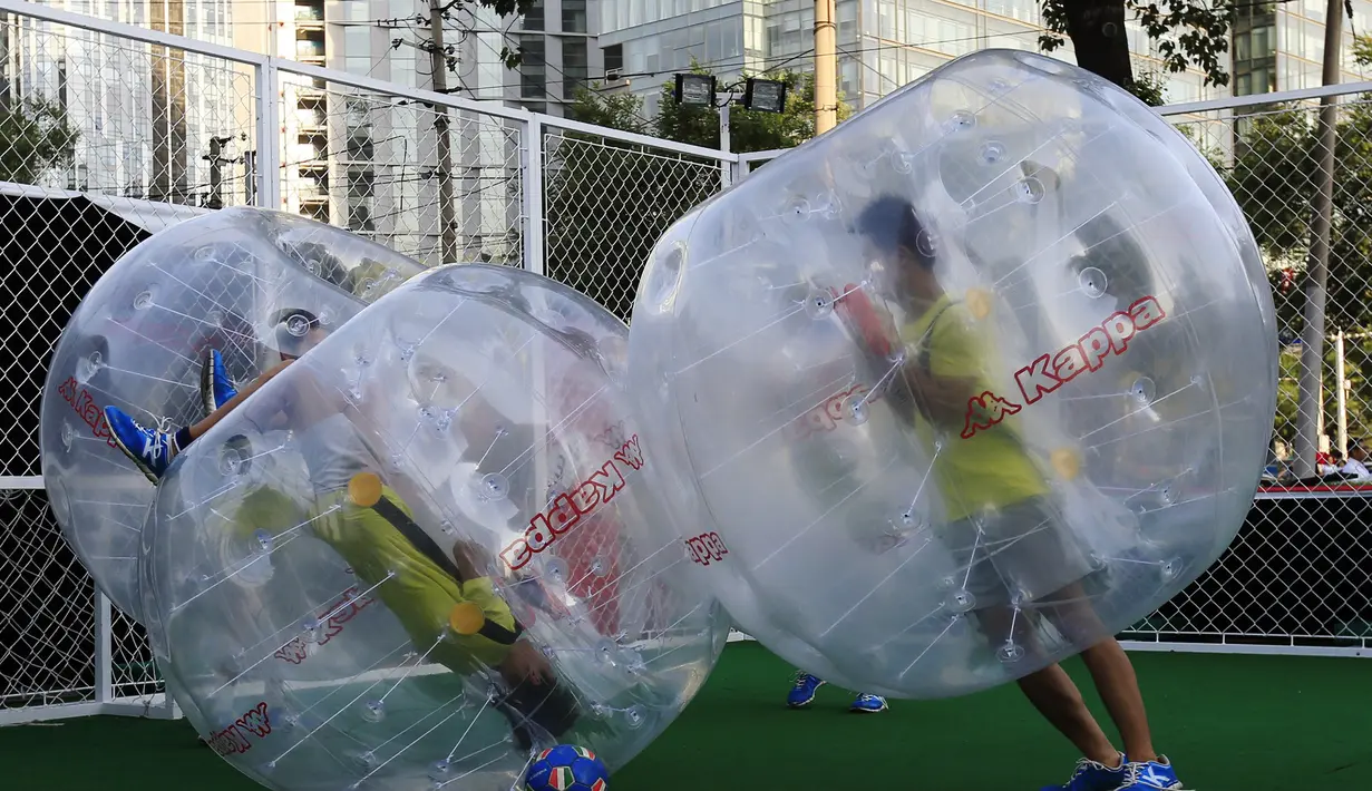 Para pemain bermain sepakbola di dalam sebuah gelembung berbentuk bola di Beijing, Kamis (10/7/14). (REUTERS/Kim Kyung-Hoon)