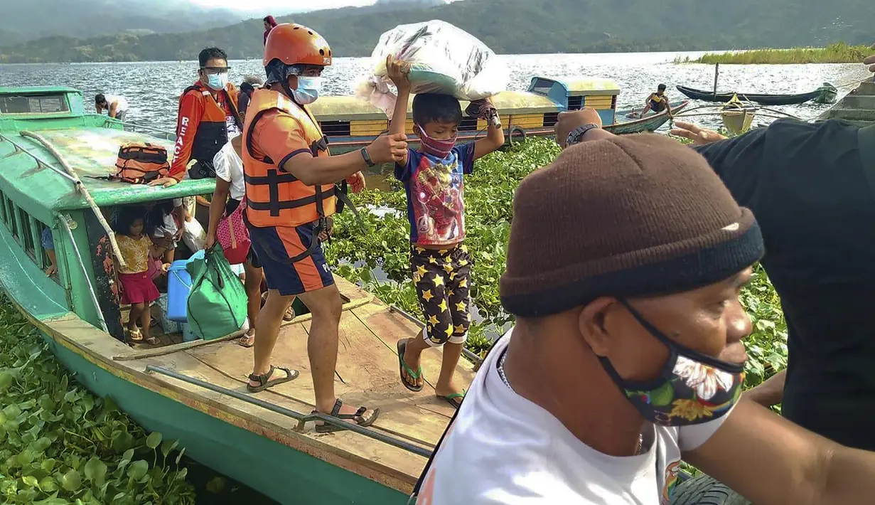 Keluarga dievakuasi ke tempat yang lebih aman di provinsi Camarines Sur, Filipina (31/10/2020). Keluarga yang tinggal di dekat kota-kota pesisir mulai pindah ke pusat-pusat evakuasi saat topan kuat mendekati negara itu. (Philippine Coast Guard via AP)