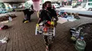 Seorang tunawisma membawa barang miliknya saat razia Satpol PP di bawah flyover Jatinegara, Jakarta Timur, Senin (19/7/2021). Hal ini juga untuk mencegah terjadinya penyebaah virus Covid-19. (Liputan6.com/Johan Tallo)