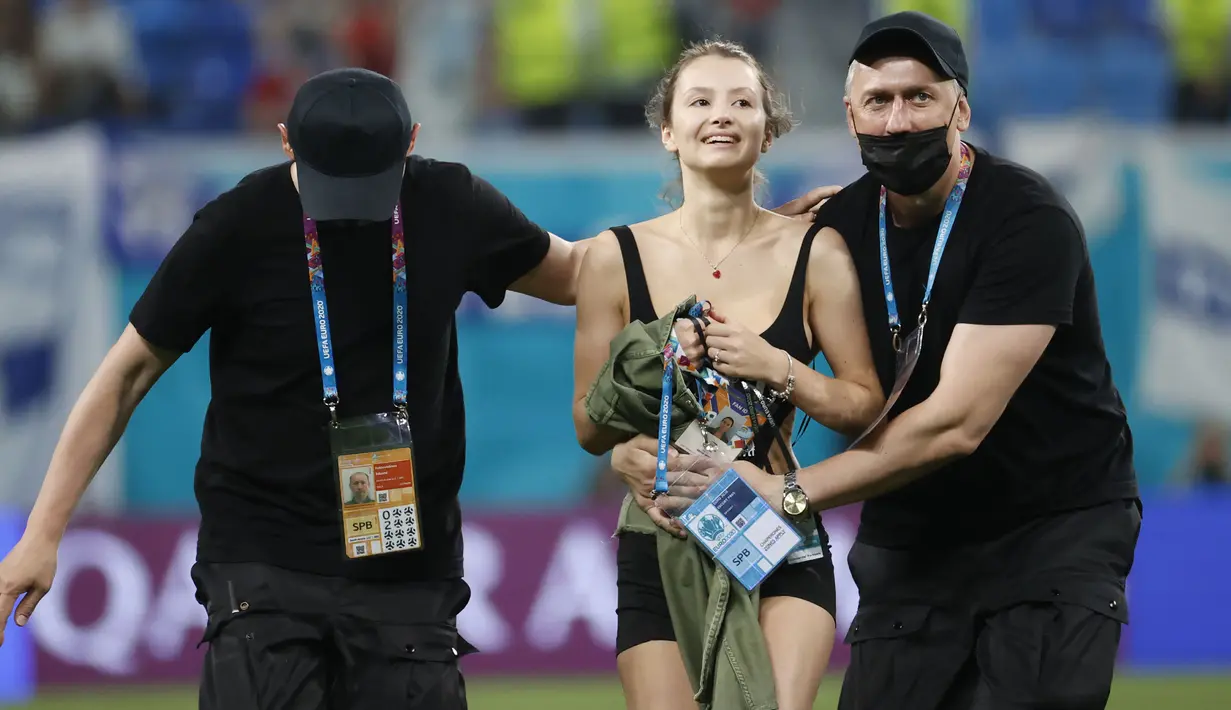 Tampaknya mungkin ada motif terselubung masuknya Pitch Invader cantik itu. Namun terlepas dari itu semua, aksi penyusup cantik seperti ini kadang menjadi bumbu pemanis pertandingan. Laga dilanjutkan dan Belgia keluar sebagai pemenang dengan skor 0-2. (Foto: AP/Pool/Anatoly Maltsev)