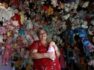 Adela Rojas (70) berpose dengan koleksi boneka-bonekanya di rumahnya di Heredia,Costa Rica (5/8/2015). Rojas telah mengumpulkan boneka selama lebih dari dua puluh tahun dan sekarang memiliki lebih dari 4.500 boneka. (REUTERS/Juan Carlos Ulate)