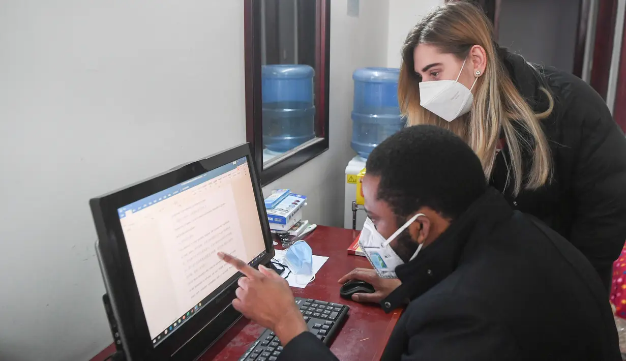 Verdi Olha dari Ukraina dan Iroegbu Paul Ikechukwu dari Nigeria mengerjakan brosur kesadaran epidemi di Universitas Chongqing di Chongqing, China, 18 Februari 2020. Pelajar asing di Chongqing ambil bagian pada kampanye pengendalian epidemi dengan terlibat di pekerjaan sukarela (Xinhua/Wang Quanchao)