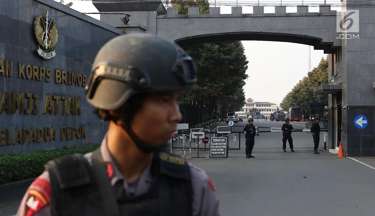 Aparat keamanan berjaga di depan pintu gerbang Mako Brimob Kelapa Dua, Depok, Jawa Barat, Rabu (9/5). Enam orang dilaporkan meninggal dalam kerusuhan yang terjadi di Mako Brimob. (Liputan6.com/Immanuel Antonius)