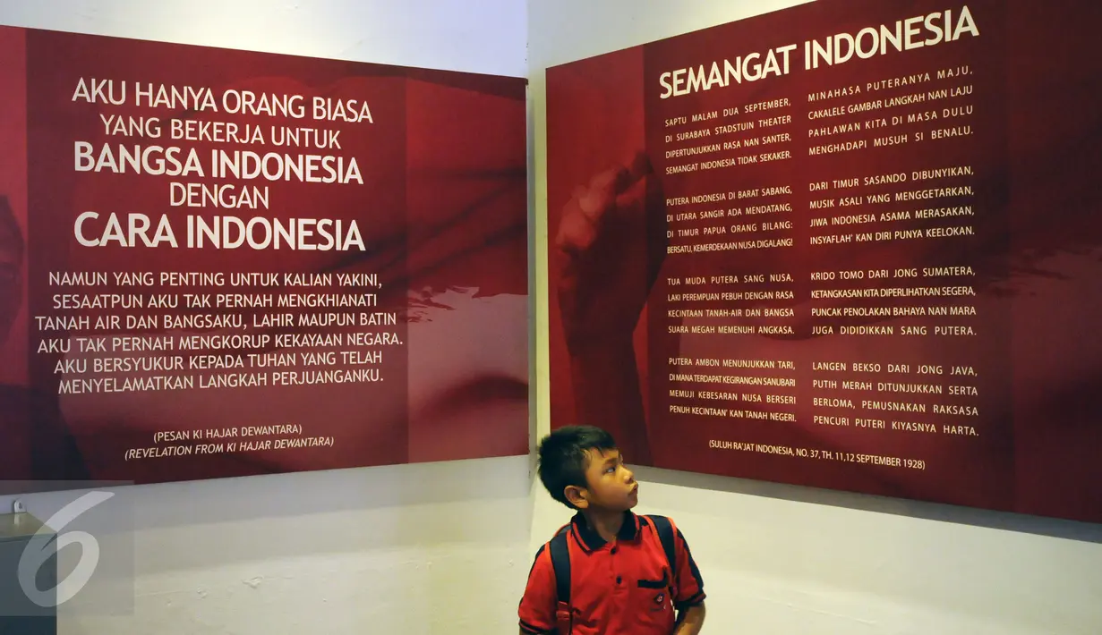 Seorang murid SD memerhatikan kutipan pesan semangat kebangsaan di Museum Sumpah Pemuda, Jakarta, Selasa (27/10/2015). Jelang peringatan 87 tahun Sumpah Pemuda, museum ini ramai dikunjungi masyarakat. (Liputan6.com/Helmi Fithriansyah)