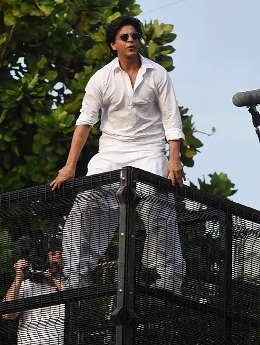 Aktor Bollywood, Shah Rukh Khan menyapa para fans pada perayaan Idul Fitri dari balkon rumahnya di Mumbai, India, Rabu (5/6/2019). Tak ingin menyia-nyiakan momen Lebaran yang dirayakan di negaranya, Shah Rukh Khan pun mengucapkan Selamat Idul Fitri di hadapan ribuan fans. (SUJIT JAISWAL/AFP)