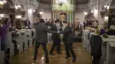 Pria menari selama hari libur Yahudi Hanukkah di Sinagoga di Vilnius, Lithuania, Minggu (28/11/2021). Perayaan tahunan komunitas malam pertama Hanukkah kembali dengan kapasitas penuh tahun ini setelah perayaan dibatasi pada tahun 2020 karena pandemi virus corona. (AP Photo/Mindaugas Kulbis)