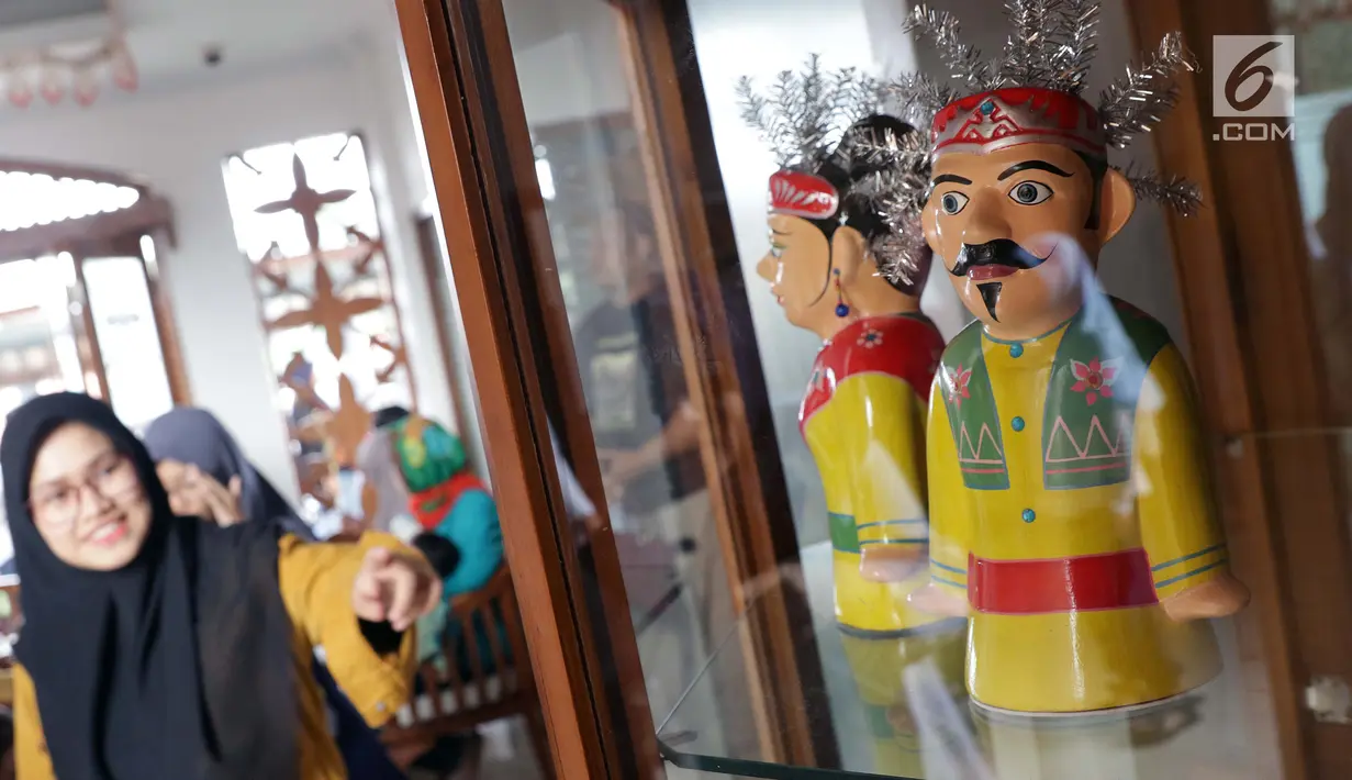 Pengunjung melihat-lihat miniatur ondel-ondel yang dipajang di Museum Betawi, kawasan Setu Babakan, Jakarta, Minggu (23/6/2019). Dalam rangka perayaan HUT ke-492 Jakarta beragam acara kebudayaan khas betawi digelar di kawasan Setu Babakan, Jakarta. (Liputan6.com/Helmi Fithriansyah)