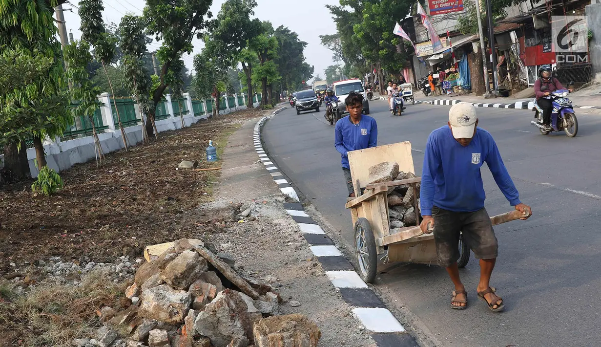Pekerja menyelesaikan pembuatan taman dan trotoar di sepanjang Jalan Raya Lenteng Agung Timur, Jakarta, Kamis (28/9). Pembuatan taman bertujuan untuk ruang terbuka hijau agar tidak disalahgunakan sebagai hunian liar. (Liputan6.com/Immanuel Antonius)