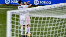 Gelandang Real Madrid, Eden Hazard berselebrasi dengan rekannya Marco Asensio usai mencetak gol ke gawang Deportivo Alaves pada pertandingan lanjutan La Liga Spanyol di stadion Mendizorroza di Vitoria, Minggu (24/1/2021). Madrid menang besar atas Alaves 4-1. (AP Photo/ Alvaro Barrientos)