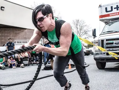 Seorang wanita menarik truk dengan tubuhnya saat kompetisi May Queen Spring Strongwoman di Lancaster, Pennsylvania, AS (25/4). Kegiatan tersebut untuk memperingati Hari Ibu. (Reuters)