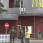 Petugas kepolisian saat mensterilkan kawasan sekitar pusat perbelanjaan Olympia, Munich, Jerman (22/7). Penyerang mulai melepas tembakan pukul 05.50 sore di gerai makanan cepat saji McDonald yang berada di seberang Olympia. (dedinac/Marc Mueller/REUTERS)