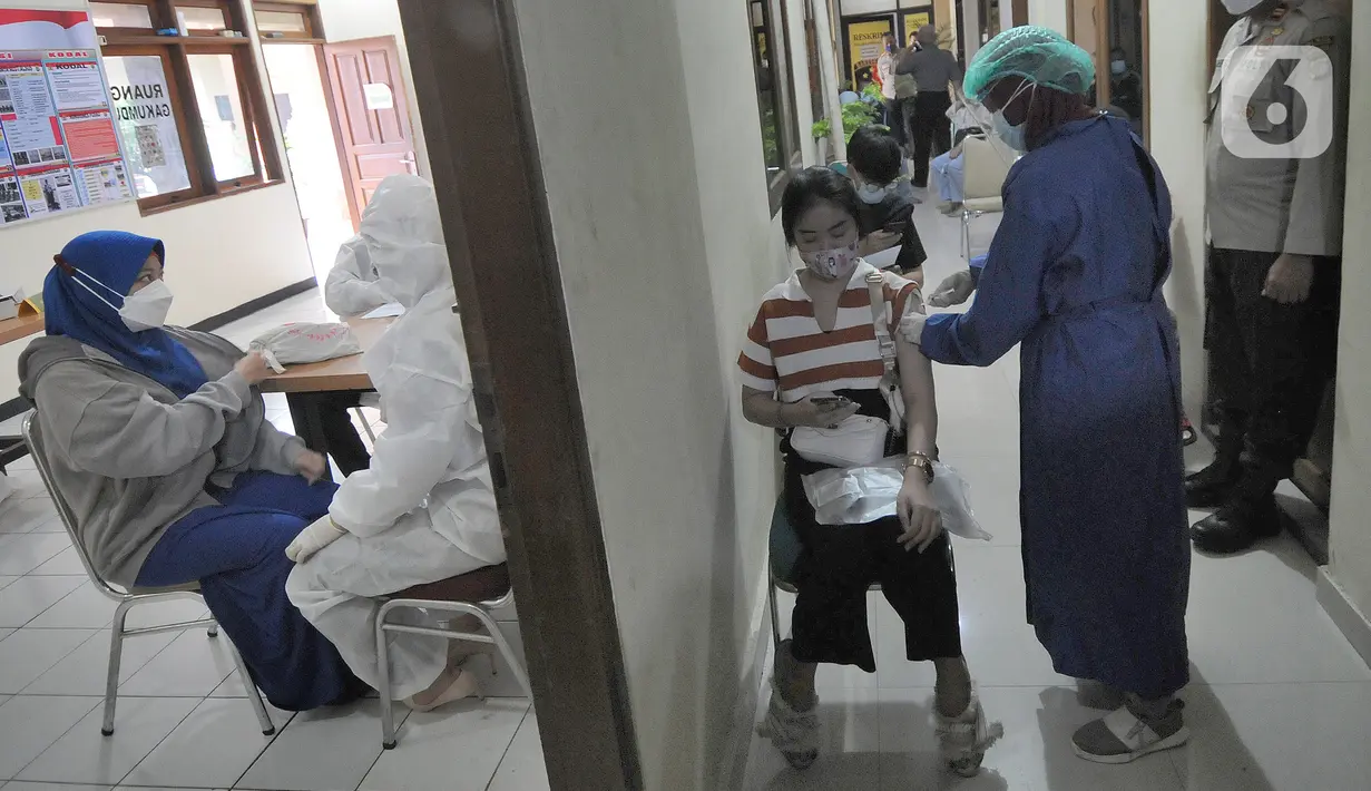 Suasana vaksinasi covid-19 Sinovac kepada warga di Polsek Pamulang, Tangerang Selatan, Kamis (1/7/2021). Sebanyak 10 ribu dosis vaksin untuk warga 18 tahun ke atas dibagikan di wilayah Polres Tangerang Selatan dalam rangka HUT Bhayangkara Ke-75 yang jatuh pada hari ini. (merdeka.com/Arie Basuki)
