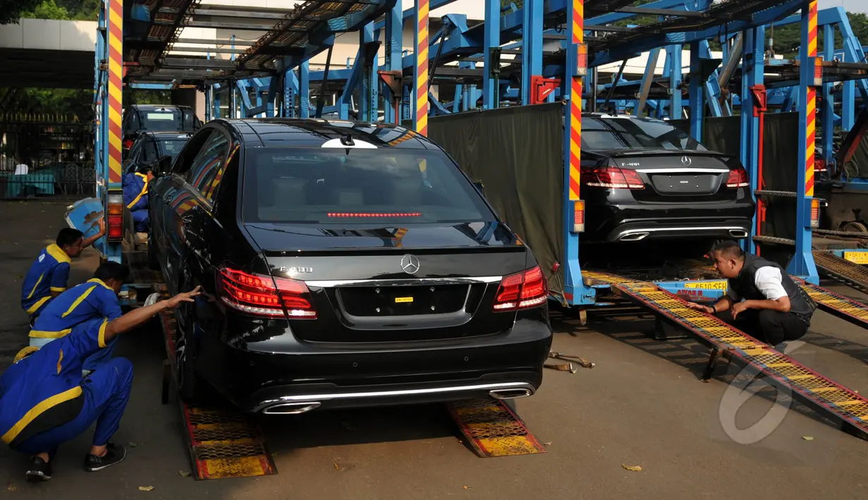 Petugas memastikan penurunan mobil untuk KAA berjalan baik, Jakarta, Kamis (16/4/2015). Sebanyak 42 mobil disiapkan Pemerintah untuk membawa Kepala Negara dalam rangkaian acara KAA ke-60 di Kota Jakarta dan Bandung. (Liputan6.com/Johan Tallo)