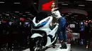 Model berpose dengan motor konsep Honda electric PCX selama Indian Auto Expo 2018 di Greater Noida, New Delhi, India, (7/2). (AFP Photo/Sajjad Hussain)