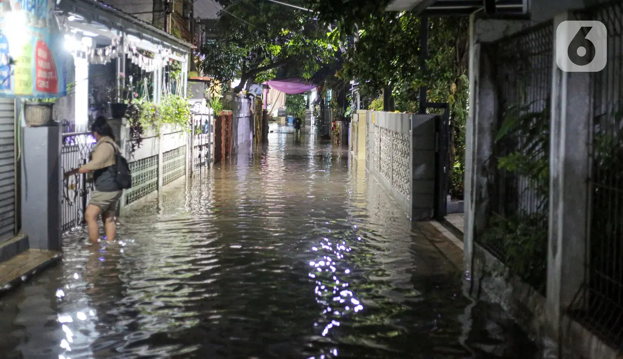 Warga berjalan menerjang banjir karena hujan di Jalan Shofa Marwah, Jakarta, Jumat (4/11/2022). Berdasarkan laporan Badan Penanggulangan Bencana Daerah (BPBD) DKI Jakarta yang diperbaharui pada pukul 18.00 WIB, terdapat 4 RT yang terendam banjir dengan ketinggian maksimal mencapai 50 Cm. (Liputan6.com/Faizal Fanani)
