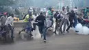  Pengunjuk rasa berlari menghindari gas air mata yang disemprotkan petugas saat bentrok di Nairobi, Kenya (16/5/2016). Mereka menuntut pembubaran otoritas pemilu karena adanya dugaan korupsi. (REUTERS/Goran Tomasevic)