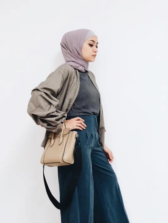 Ibu dari Dia Sekala Bumi ini memang gemar mengenakan busana berwarna pastel. Coba lihat, ia memakai celana kulot berwarna hijau toska gelap dan dipadukan dengan atasan abu-abu beserta outer coklat. (Instagram/ayudiac)