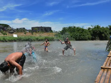 Anak-anak bermain pada aliran Sungai Cisadane di kawasan Keranggan, Setu, Tangerang Selatan, Banten, Minggu (20/3/2022). Cuaca panas terik dimanfaatkan mereka untuk berendam sambil bermain. (merdeka.com/Arie Basuki)
