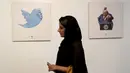 Pengunjung wanita Iran melintas di depan kartun Presiden AS Donald J. Trump di sebuah pameran kartun Trumpisme 2017 Internasional dan kontes karikatur, di ibukota Teheran, Iran (3/7). (AFP Photo/Atta Kenare)