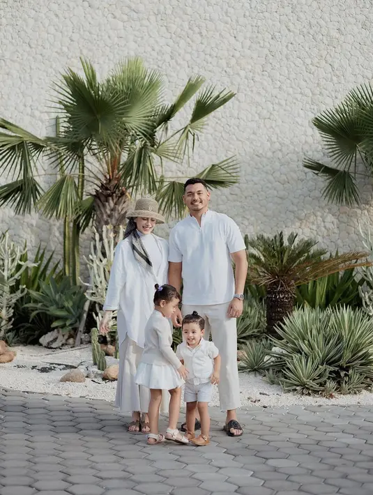 Inspirasi outfit keluarga berwarna putih. Aghnia Punjabi tampil cantik dengan turtleneck yang ditumpuknya dengan oversized shirt putih, dipadu dengan rok cokelat. Sedangkan Baby Cana terlihat mengenakan sweater cokelat yang dipadunya dengan rok putih. [Foto: Instagram/emyaghnia]