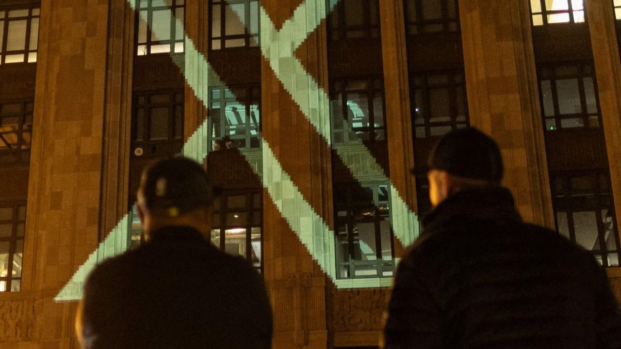 Penampakan itu sempat membuat heboh pejalan kaki yang melintasi depan gedung tersebut. Beberapa orang yang penasaran juga ada yang bertanya-tanya kemunculan logo itu.
( REUTERS/Carlos Barria )