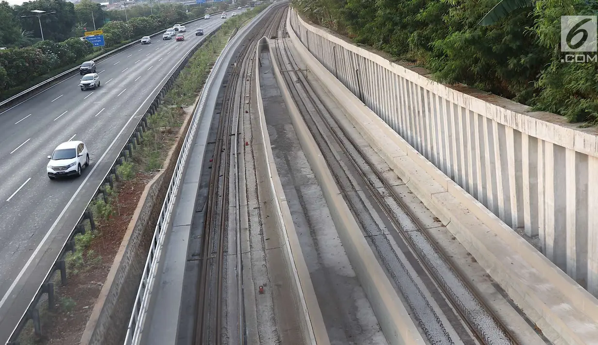 Kendaraan melintas di samping proyek proyek Light Rail Transit (LRT) Jabodebek di Jakarta, Minggu (12/8). Proyek LRT Jabodetabek ditargetkan rampung pada 2019. (Liputan6.com/Immanuel Antonius)