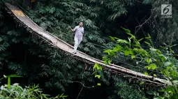 Jembatan yang berada di atas Sungai Ciliwung ini menjadi salah satu akses bagi warga untuk mempersingkat waktu menyeberang Lenteng Agung, Jakarta, Rabu (24/5). (Liputan6.com/Immanuel Antonius)