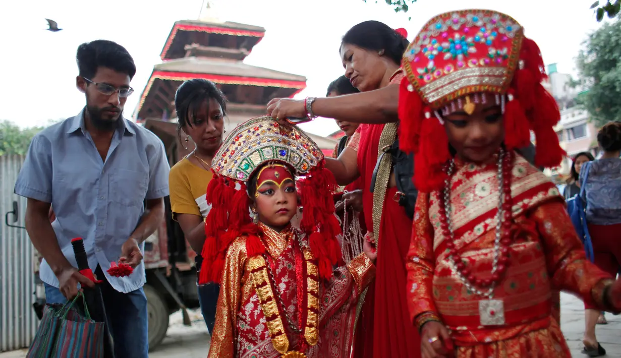 Seorang wanita membantu putrinya bersiap mengikuti pemujaan Kumari di Hanuman Dhoka, Kathmandu, Nepal, Senin (4/9). (AP Photo/Niranjan Shrestha)