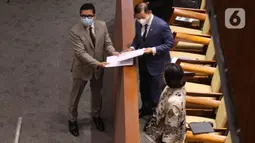 Ketua Pansus IKN Ahmad Doli Kurnia memberikan dokumen hasil sidang Pansus Rancangan Undang-Undang Ibu Kota Negara (RUU IKN) kepada Menteri PPN/Kepala Bappenas) Suharso Monoarfa pada Rapat Paripurna ke-13 DPR RI di Kompleks Parlemen, Jakarta, Selasa (18/1/2022). (Liputan6.com/Angga Yuniar)