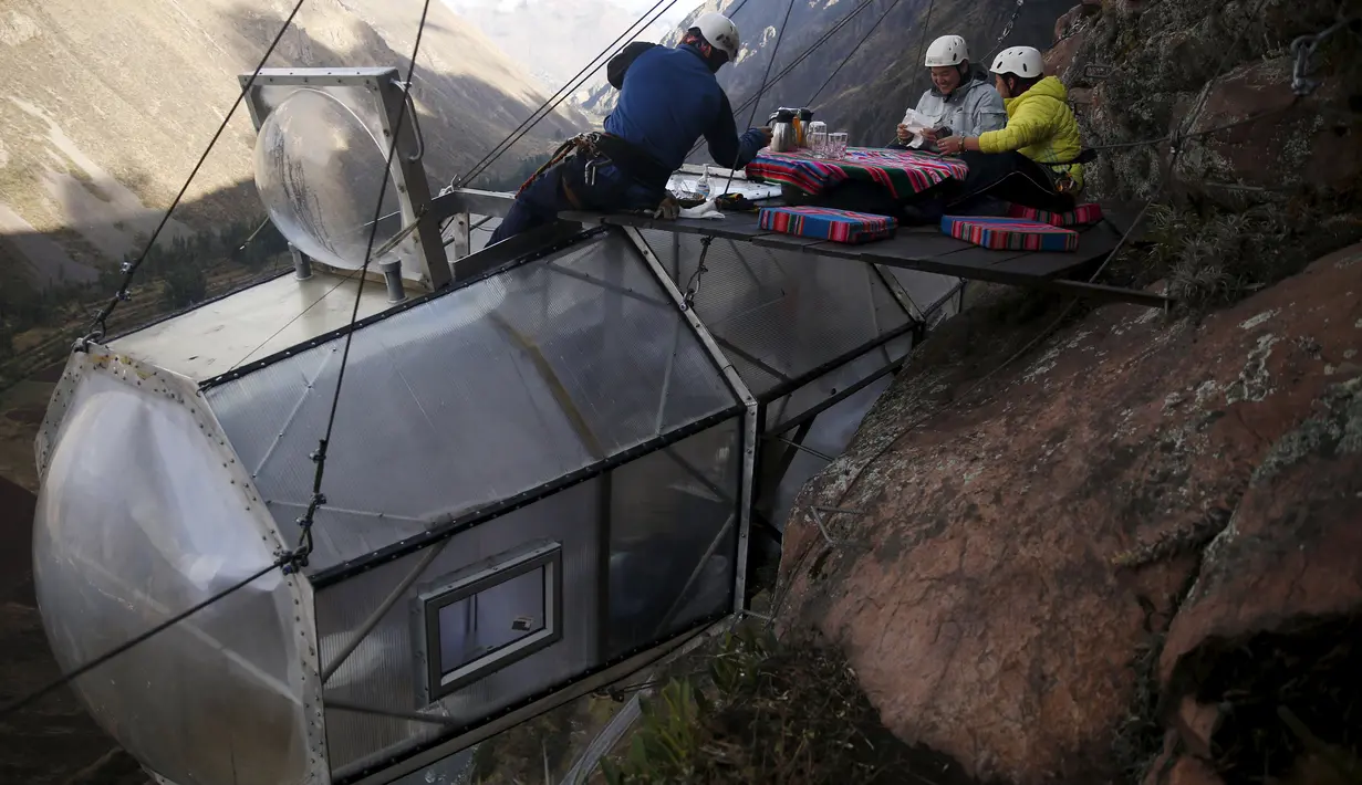 Pemandu menyajikan sarapan kepada tamu di atas kapsul tidur di Skylodge Adventure Suites di Lembah Suci di Cuzco, Peru, 14 Agustus 2015. Hotel  tergantung dengan ketinggian 400 meter ini memiliki tarif sekitar Rp 4 juta per malam. (REUTERS/Pilar Olivares)