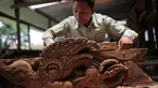 Seorang pengrajin kayu dari komunitas etnis Newar mengukir kayu di Lalitput, Nepal (19/7). Komunitas pengrajin kayu ini memperbaiki pintu dan jendela kayu yang rusak akibat gempa Nepal menjadi kayu ukiran yang menawan. (AP Photo/Niranjan Shrestha)