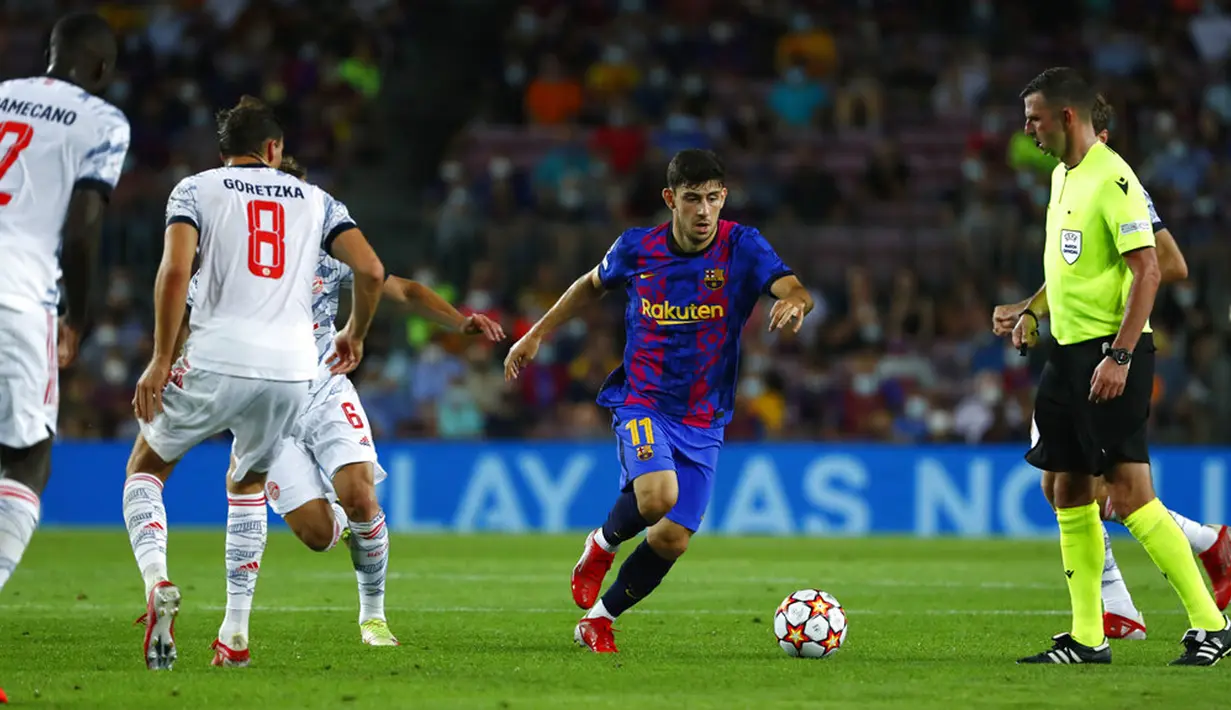Pemain Barcelona Yusuf Demir (tengah) berebut bola dengan pemain Bayern Munchen Joshua Kimmich pada pertandingan Grup E Liga Champions di Stadion Camp Nou, Barcelona, Spanyol, Selasa (14/9/2021). Bayern Munchen menang 3-0. (AP Photo/Joan Monfort)