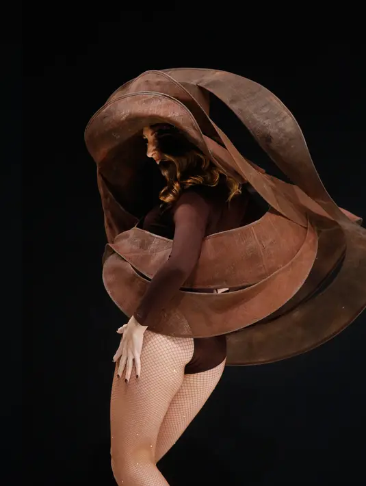 Seorang model menampilkan gaun yang dibuat dari bahan cokelat hitam dalam sebuah pameran yang dikombinasikan dengan fashion show di Paris, 27 Oktober 2017. Pameran tersebut bertajuk Salon Du Chocolat. (AP Photo/Thibault Camus)