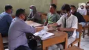 Petugas menyerahkan bantuan sosial (bansos) dari Pemerintah Provinsi Banten kepada warga di Pinang, Tangerang, Jumat (1/5/2020). Bansos berupa uang tunai sebesar Rp 600 ribu tersebut diberikan kepada warga yang terdampak virus corona COVID-19. (Liputan6.com/Angga Yuniar)