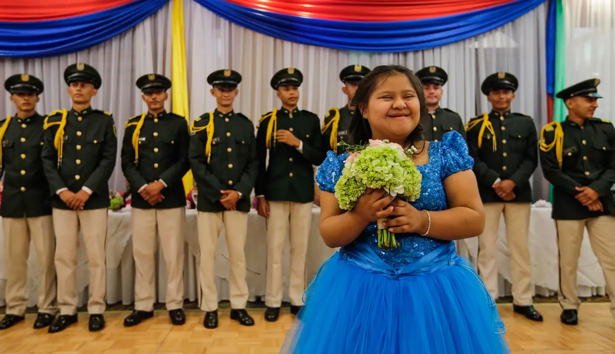 Seorang gadis berpose di depan para tentara selama perayaan ulang tahun massal untuk pasien kanker di Managua, Nikaragua, Sabtu (21/10). Perayaan ultah massal ini diselenggarakan Asosiasi Ibu dan Anak Nikaragua dengan Leukemia dan Kanker. (INTI OCON/AFP)