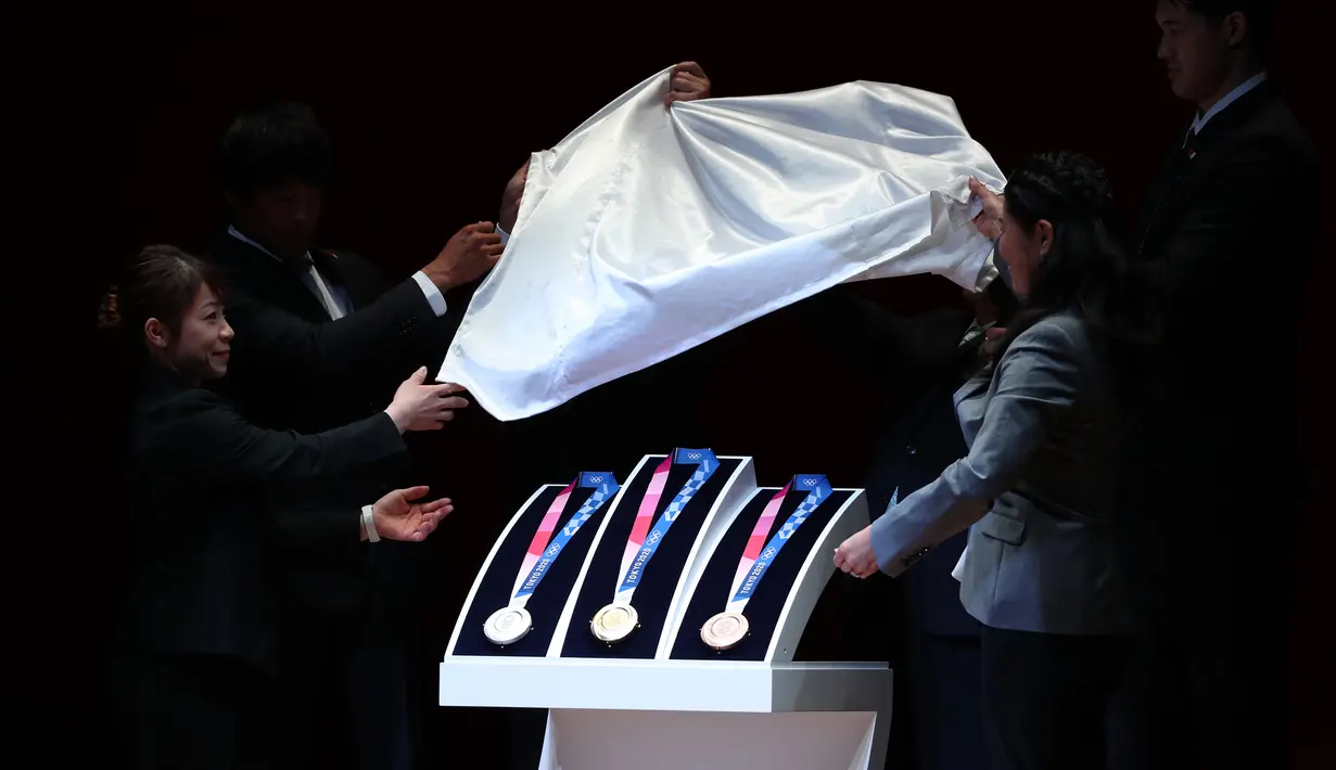 Medali Olimpiade Tokyo 2020 resmi diumumkan kepada publik saat seremoni untuk merayakan momen satu tahun jelang Olimpiade di Tokyo, Rabu (24/7/2019). Medali yang didesain Junichi Kawanishi itu berdiameter 85 mm dan dihiasi gambar dewi Yunani, Nike serta logo Olimpiade. (Behrouz MEHRI/AFP)
