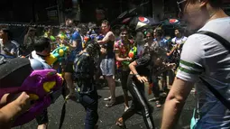 Orang-orang bersuka cita saling menyemprotkan air selama Festival Songkran di Silom Road, Bangkok, Jumat (13/4). Festival Songkran merupakan Tahun Baru Thailand dimulai dari tanggal 13 April sampai 15 April. (LILLIAN SUWANRUMPHA/AFP)