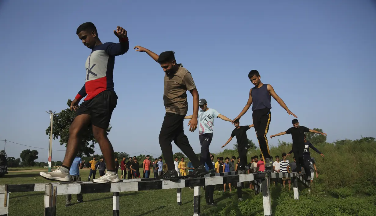Pemuda India yang ingin bergabung dengan pasukan pertahanan menjalani pelatihan fisik di desa Jhiri dekat perbatasan India Pakistan, pinggiran Jammu, India, Rabu (6/10/2021). Pelatihan fisik ini digelar oleh Pusat Pelatihan dan Pemberdayaan Pemuda Perbatasan (C-BYTE). (AP Photo/Channi Anand)