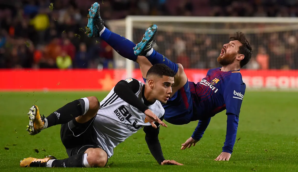 Pemain Valencia, Andreas Pereira berbenturan dengan pemain Barcelona, Lionel Messi pada semifinal pertama Copa del Rey di Stadion Camp Nou, Jumat (2/2). Barcelona menang 1-0 berkat gol semata wayang Luis Suarez. (AFP PHOTO/LLUIS GENE)